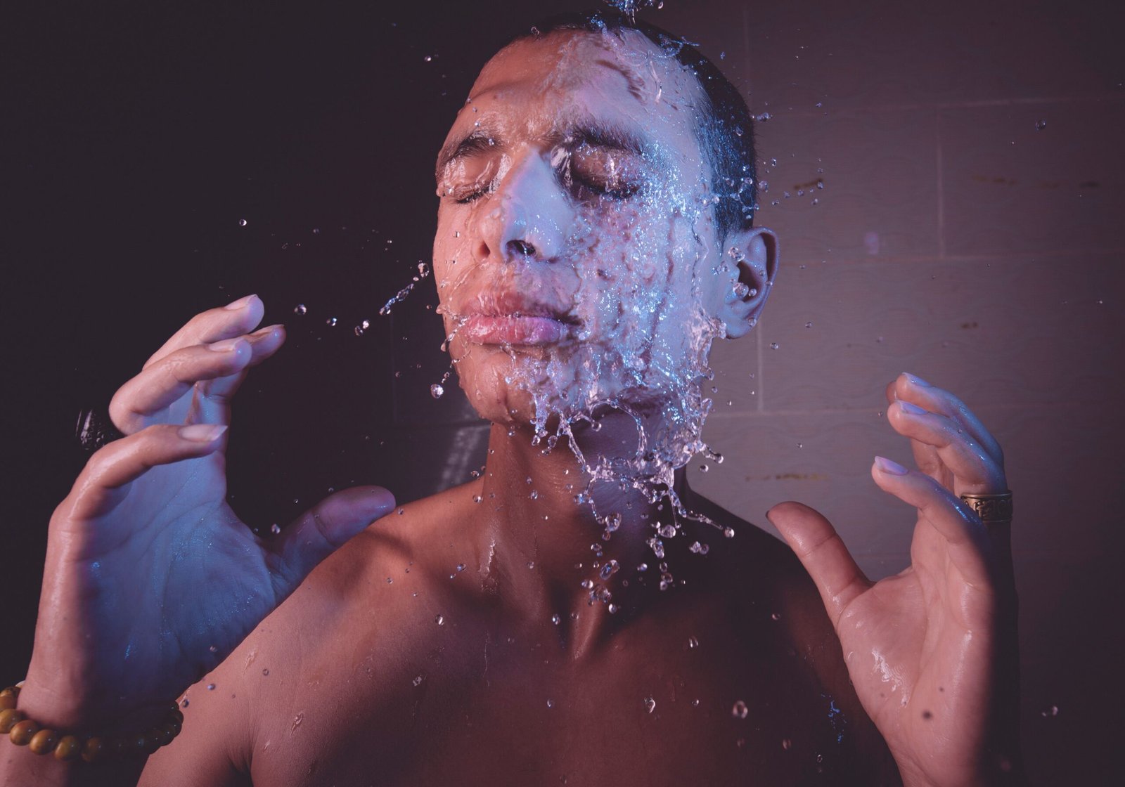 Man enjoying a refreshing cold water splash on his face, illustrating the alertness benefit of cold exposure