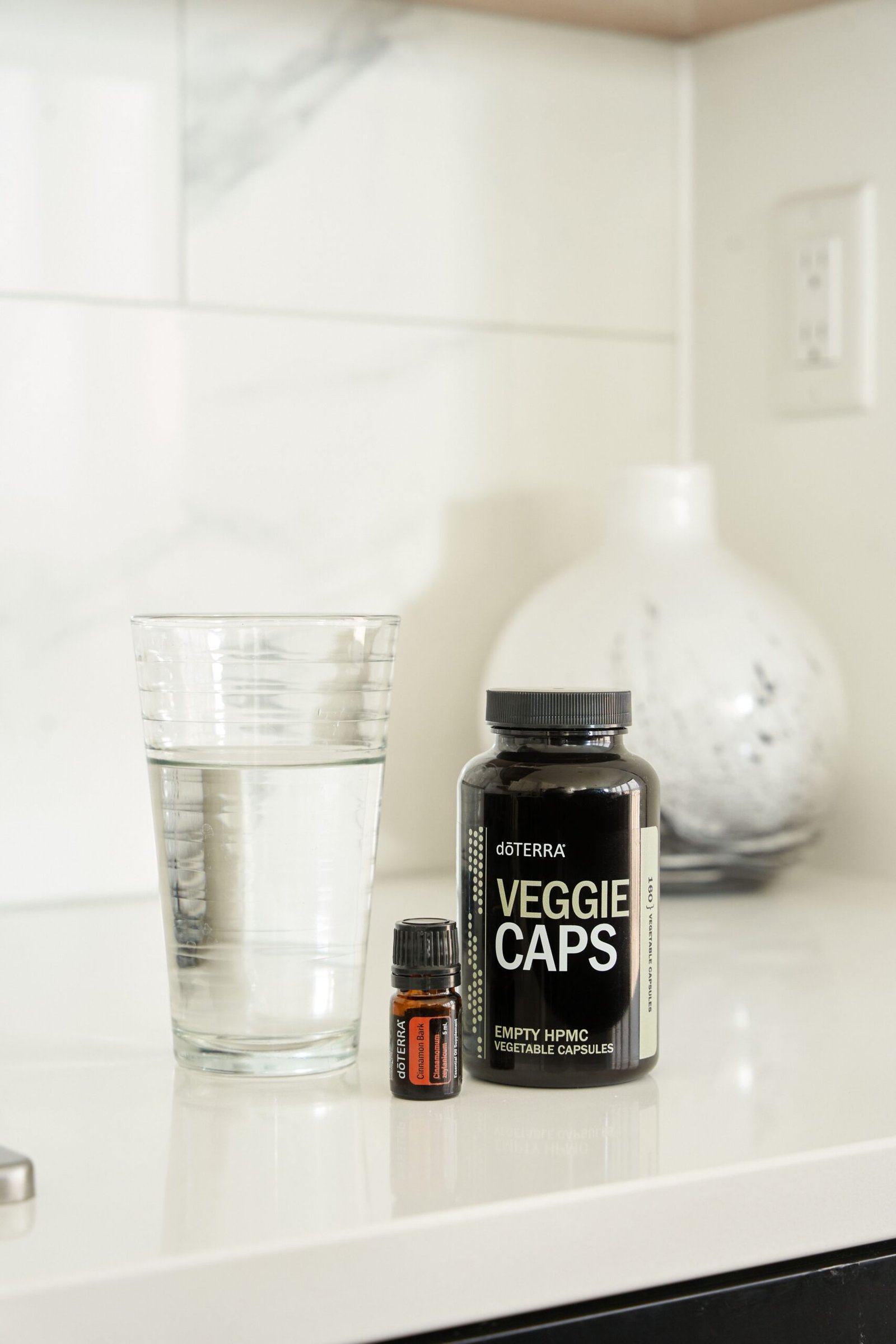 Vitamin capsule bottle beside a glass of water, illustrating collagen and other supplement intake