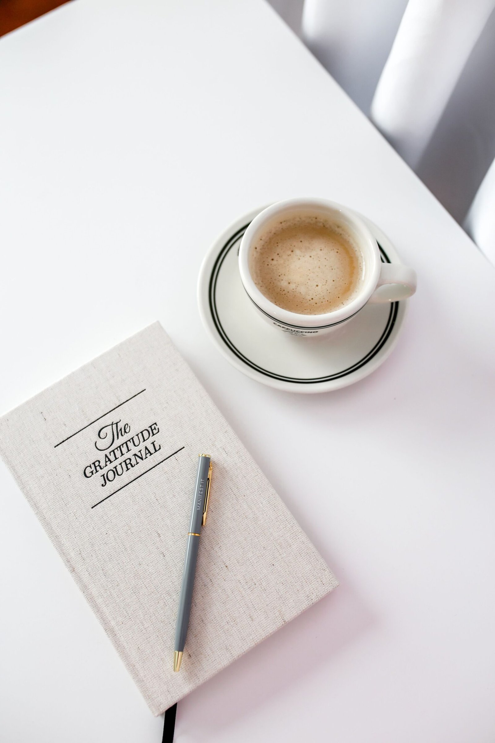 Gratitude journal with a cup of coffee on a bright table, set up for a daily gratitude practice