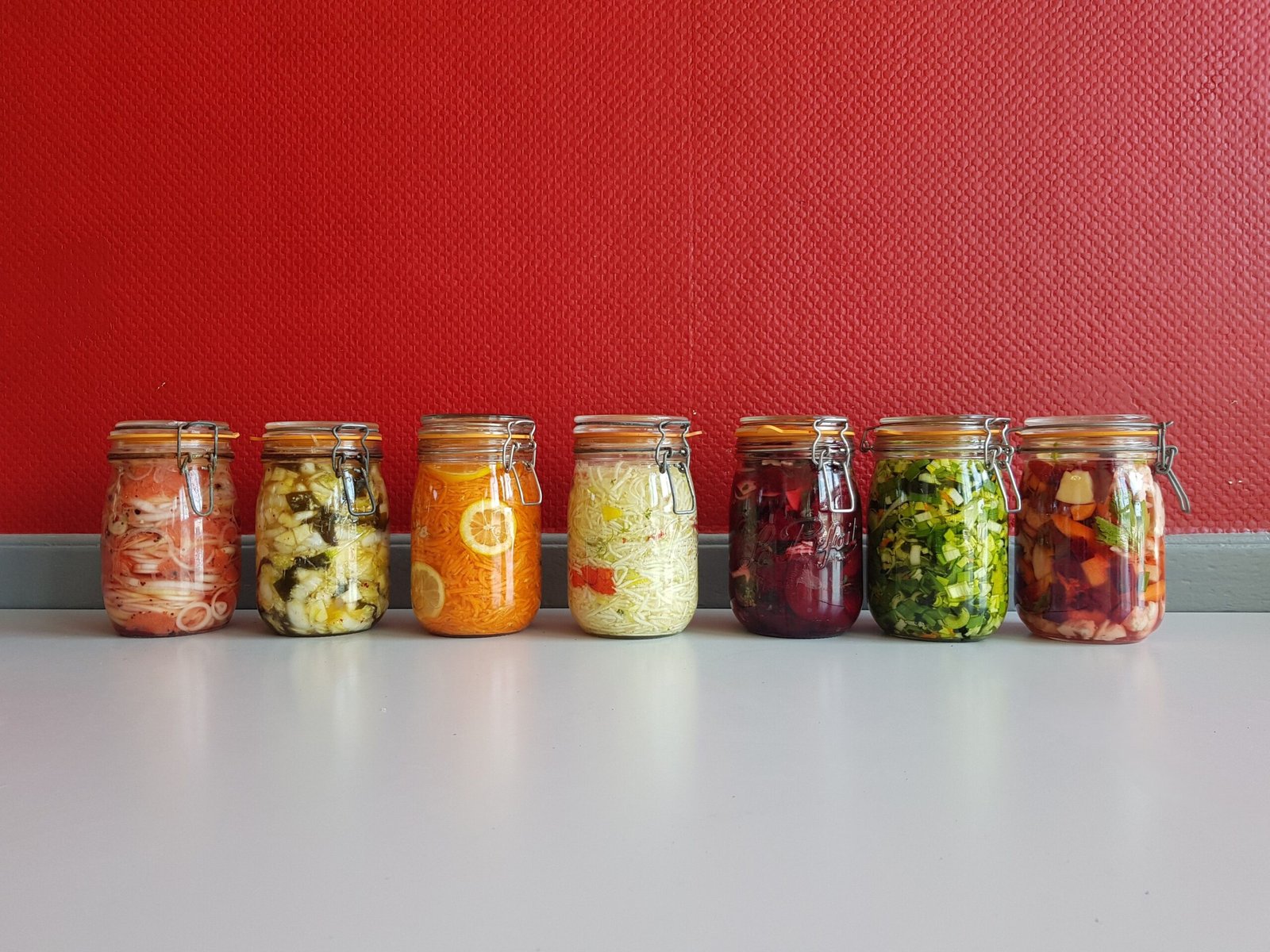 Row of colourful fermented vegetables in mason jars, natural probiotic food sources for gut and immune health