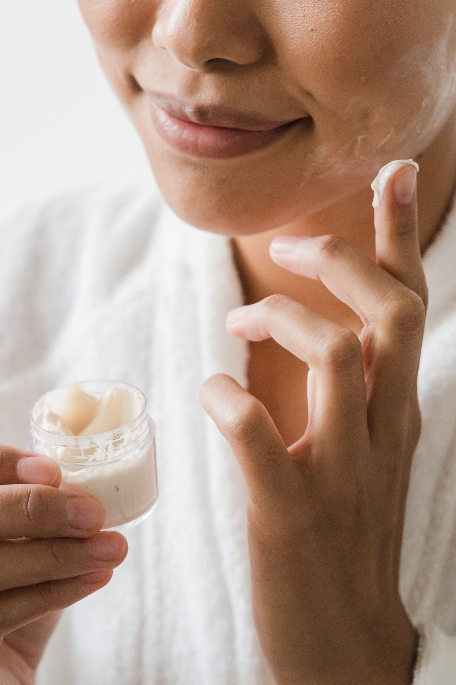 Woman applying facial cream, part of an evening retinol anti-ageing skincare routine