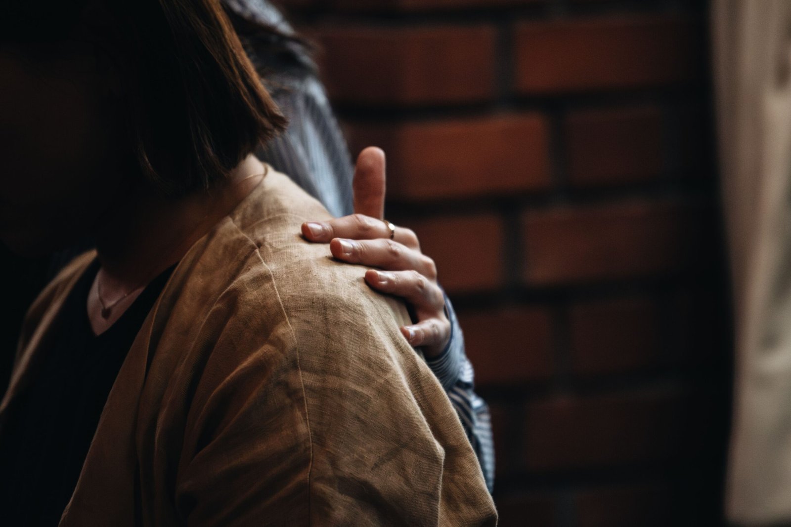 A comforting hand on a person's shoulder, symbolizing emotional support during grief