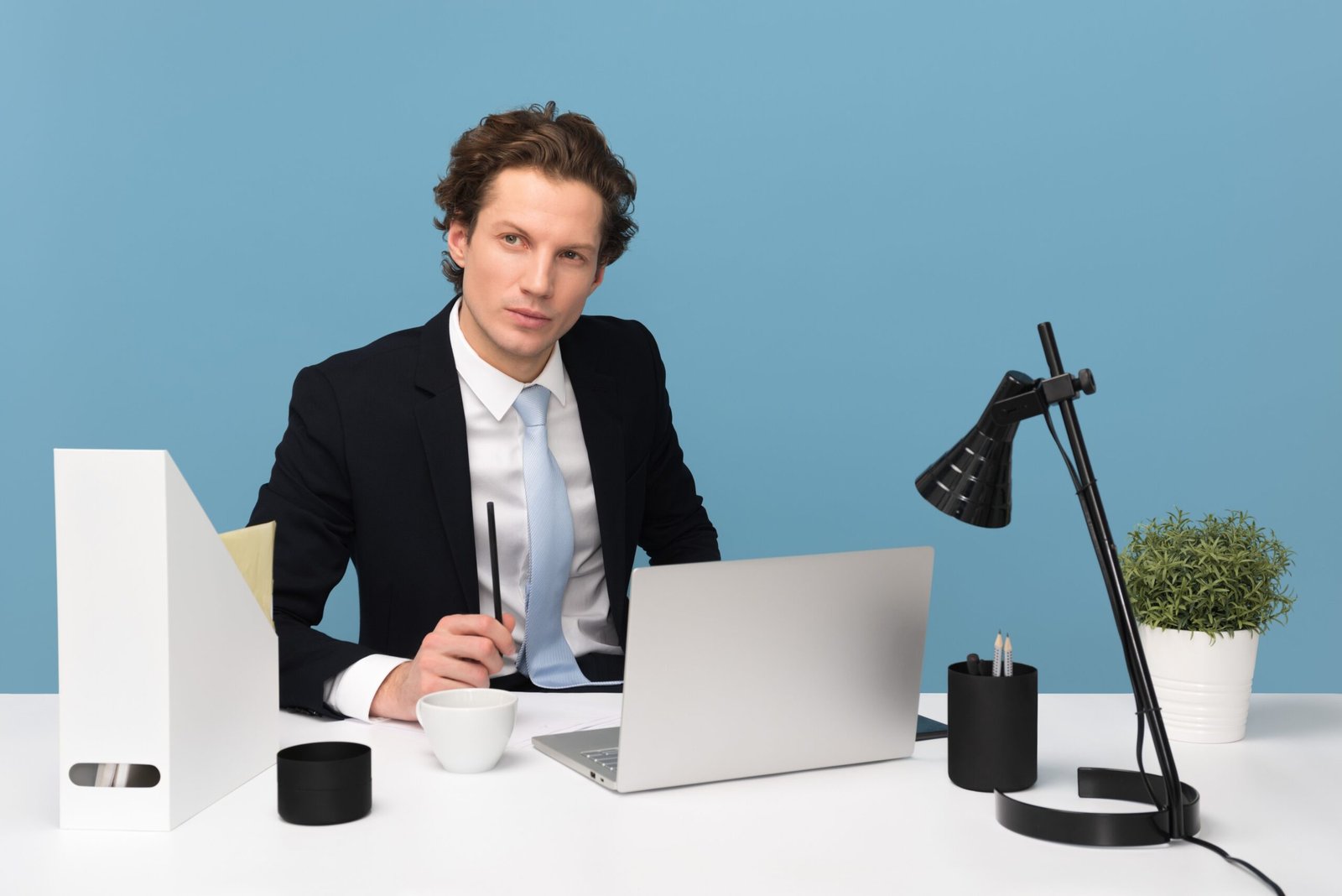 Focused man working at a tidy desk with a laptop and lamp, illustrating deep, distraction-free concentration