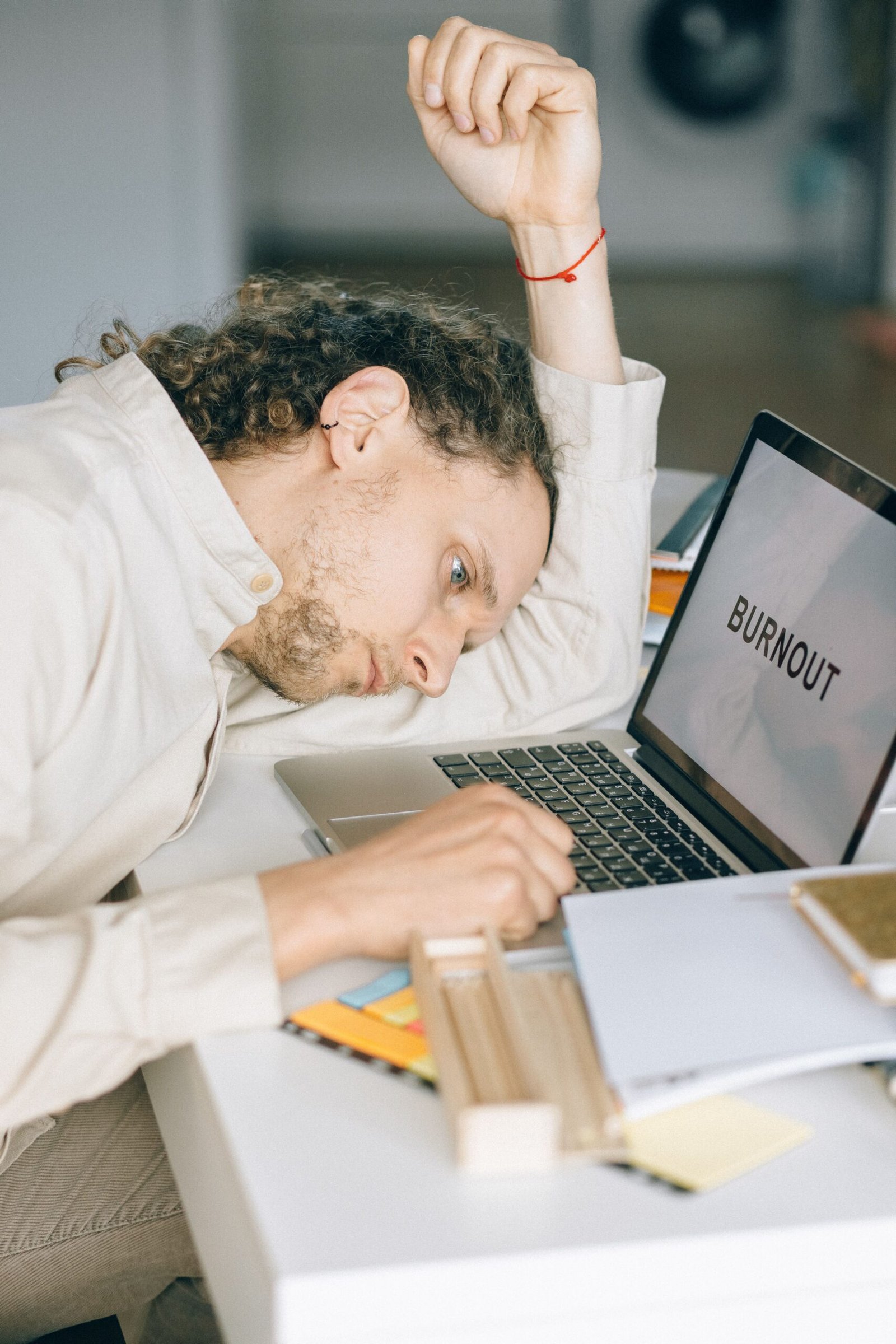 Exhausted employee resting head on desk, showing signs of burnout