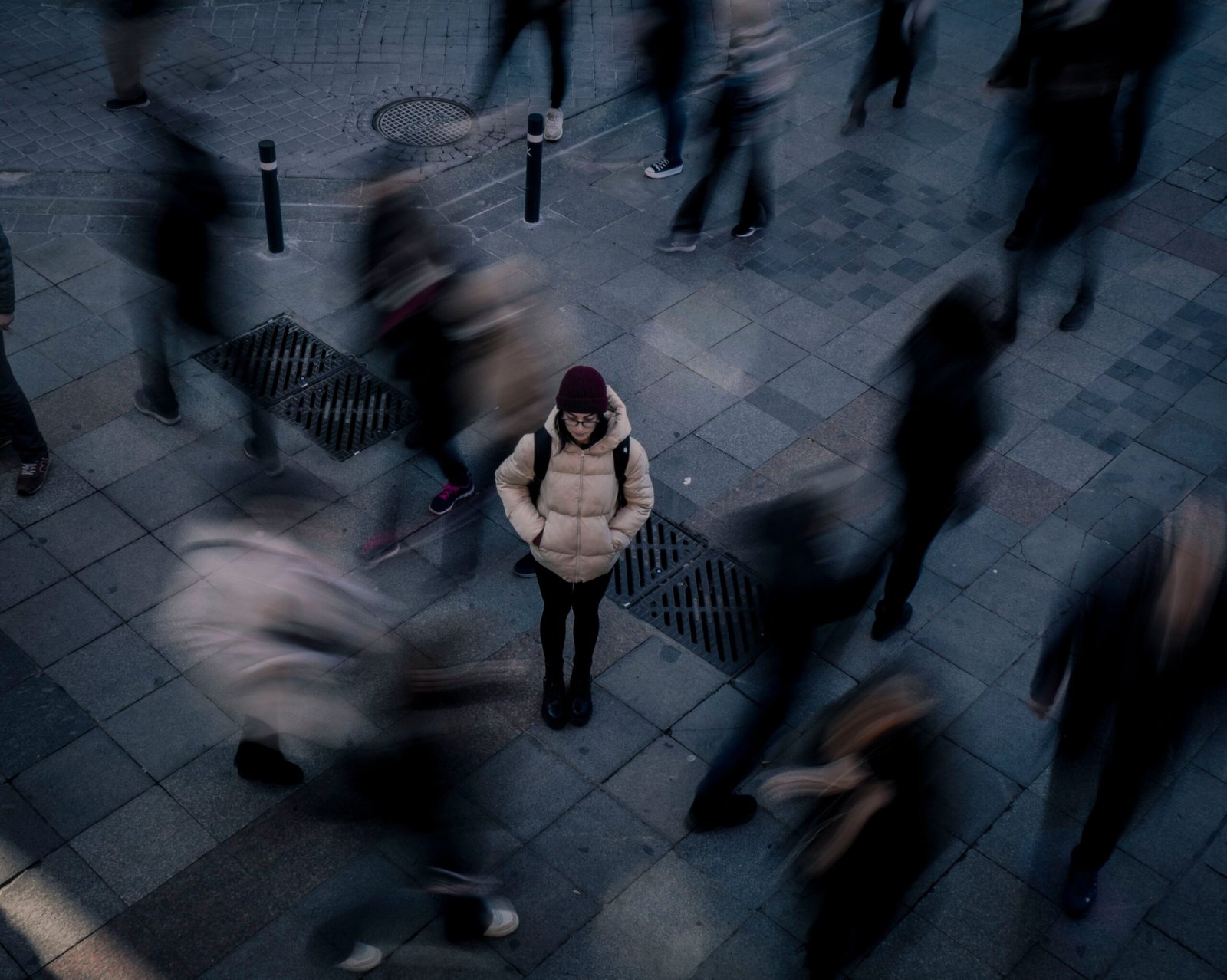 Woman standing still as a crowd moves around her, illustrating the isolation of social anxiety