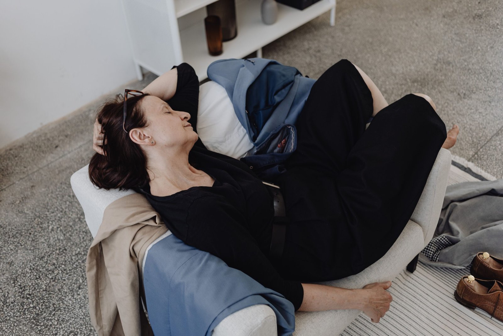 Tired woman resting on a sofa, illustrating the persistent fatigue common with an underactive thyroid